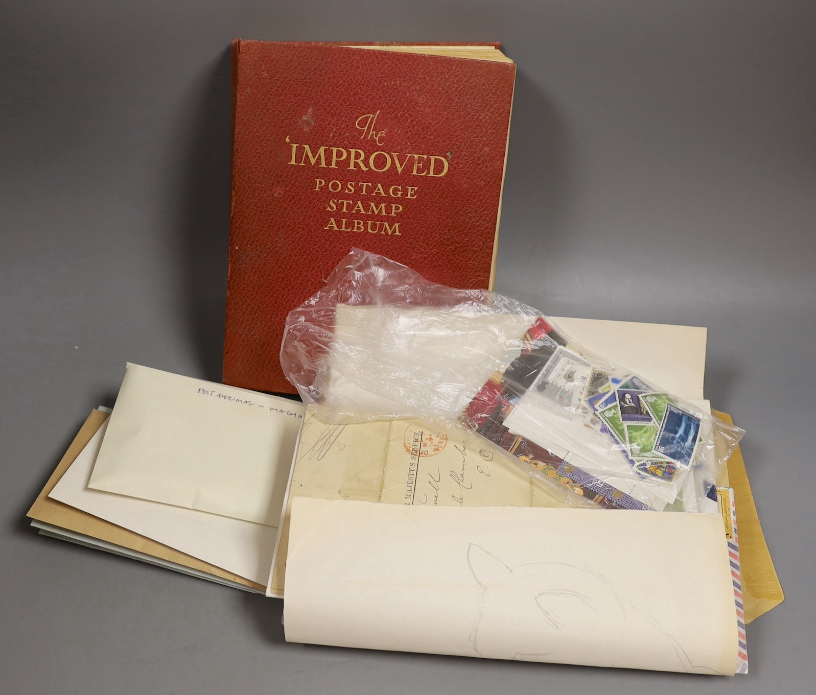 A stamp album of world stamps and a collection of loose stamps.